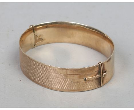 A ladies 9ct gold Art Deco bangle with engine turned decoration metal core, gross weight 40.11 gross weight.