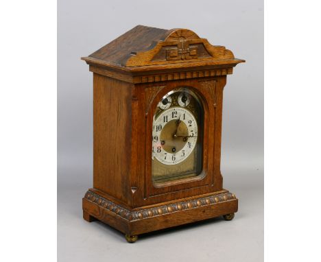 A carved oak bracket clock with egg and dart decoration having an etched dial and housing a three train movement.