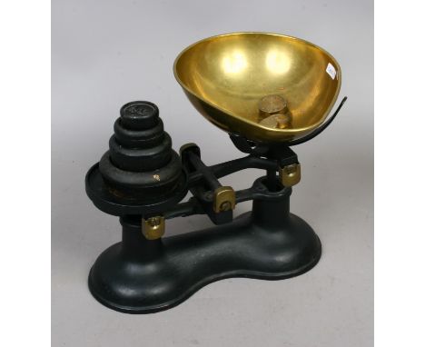 A set of cast iron weighing scales with weights.