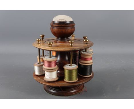 A mahogany revolving bobbin stand with pin cushion, 7 1/2" high 