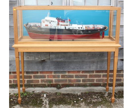 A scale model "Seabee" tug boat, 43" long x 9 1/2" wide approx, in light oak case, 53 3/4" wide x 17 3/4" deep x 52" high 