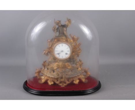 A 19th century gilt spelter mantel clock with hunter surmount, 14" high, under a glass dome shade, on oval ebonised base 
