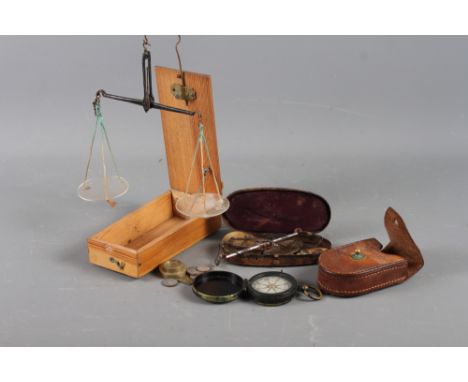 A WWI compass in leather case, an apothecary's balance and weights, in wooden case, and a similar balance, in Japanned case 