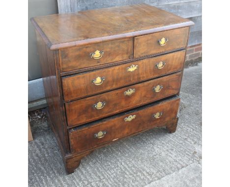 A mid Georgian walnut and banded chest of two short and three long graduated drawers with original brass handles, escutcheons