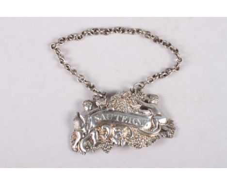 An early 19th century cast silver "Sauterne" decanter label / bottle ticket, decorated putti, Bacchus and grapes 