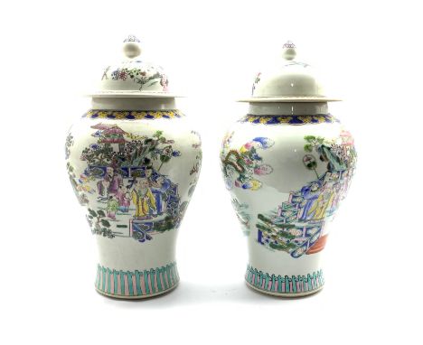 Near pair 20th Century Chinese Baluster vases and covers, each painted with figures in a garden pavilion, with Kangxi Charact