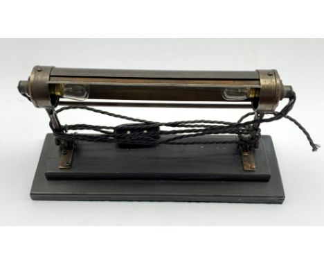 Adjustable picture light, mounted on an ebonised two tier stand