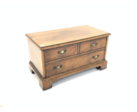 Reproduction walnut television stand with false drawer faced fall front cupboard, raised on bracket feet and castors, W82cm C