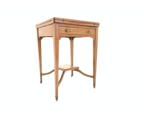 Edwardian satinwood envelope top games table with ebonised string and boxwood inlay, hinged revolving top revealing inset wel