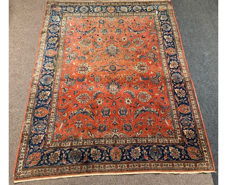 Persian design ground carpet, red field with all over trailing foliate design, double guarded blue border, 300cm x 390cm Cond