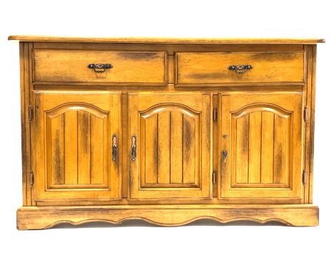 20th century light oak sideboard, with two drawers above two panelled cupboards, on shaped plinth base, W130cm, H80cm, D46cm 