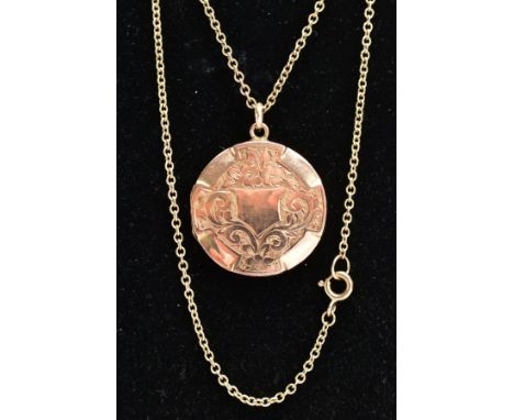 A LOCKET PENDANT NECKLACE, the gold front and back locket of a circular form, decorated with a foliate and scroll pattern and