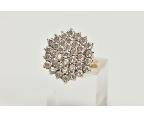 A 9CT GOLD CUBIC ZIRCONIA CLUSTER RING, thirty seven circular cut cubic zirconia within a yellow metal prong setting, leading