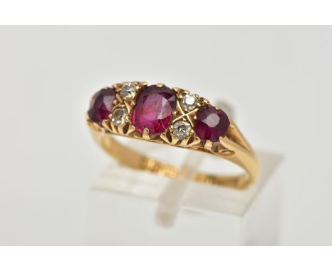 A 18CT GOLD RUBY AND DIAMOND RING, three cushion cut rubies set with four old cut diamonds in a yellow gold prong setting, de