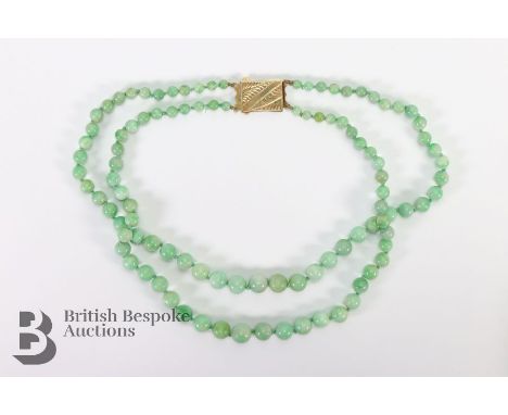 Graduated nephrite jade two row necklet, the graduated beads measure from 9.75mm to 4.5mm, with a rectangular silver gilt eng