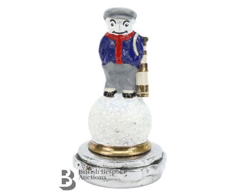 A Dunlop golfer accessory mascot of a golfer standing on a golf ball, mounted on a radiator cap. The mascot with painted clot