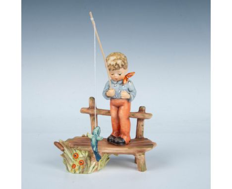 Matte painted boy fishing on wood plank. Fish hanging from string. Goebel backstamp. Artist's signature on bottom. First issu