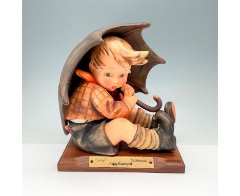 This classic figurine depicts a hand-painted boy hiding under an umbrella. This item has a wooden base included which measure