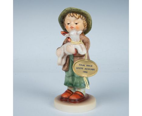 This porcelain figurine depicts a young shepherd boy with a little lamb. Crafted in matte finish. Goebel backstamp TMK7. Arti