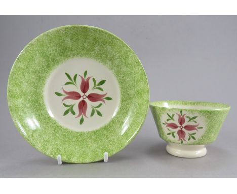 A nineteenth sponge decorated and hand-painted tea bowl and saucer, c. 1850-70. It is decorated with green sponging to the ri
