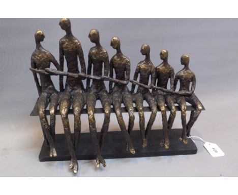 In the style of Giacometti, a sculpture of figures sitting on a bench. 