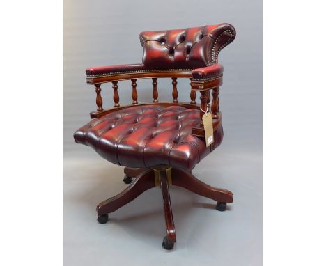A 20th Century mahogany captain's desk with red leather button back upholstery, raised on splayed legs and castors. 