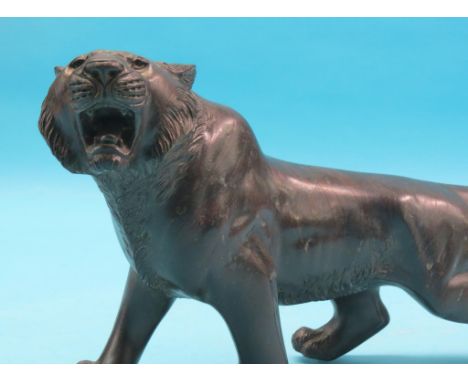 An hollow-cast bronze tiger, four-square and roaring, unsigned, 15in. long