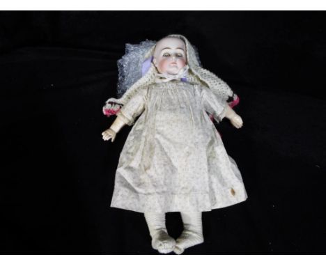 A ceramic headed doll marked to the rear with the number 8 with glass sleeping eyes, closed mouth and jointed composition bod