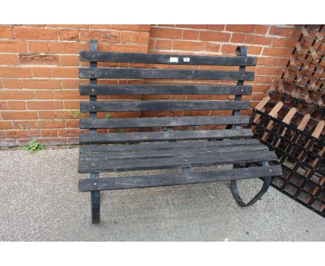 A teak and black iron garden bench of small proportions
