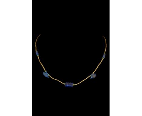 Ca. 2000-1000 BC.A restrung necklace with small gold beads, alternating with green discoid and lapis lazuli beads. Lapis lazu