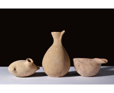 Ca. 2000-1000 BC.A set of three terracotta vessels. Among them, a cup with a near-hemispherical shape. It has a side spout fo