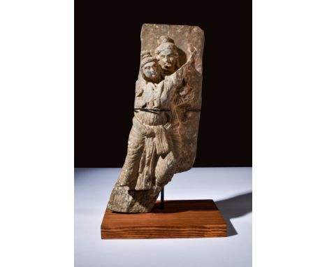 Ca. 200-300 AD.A schist frieze depicting a couple. The woman stands in front of the man, leaning over with a bent leg and lef