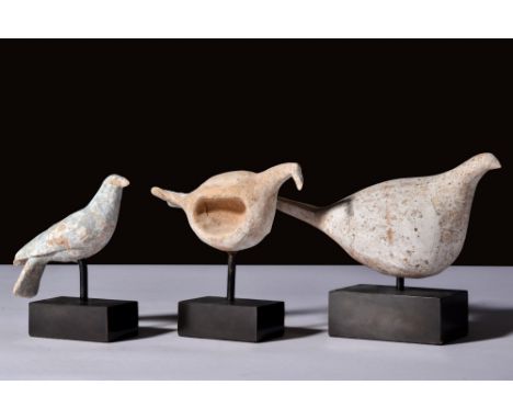 Ca. 300 BC.A set of three pottery birds. One is round, with a small head and flaring tail. The second is depicted as if in fl