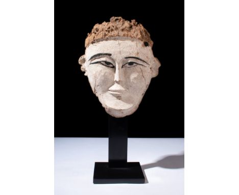 Late Dynastic Period, Ca. 664-32 BC.A wood-carved sarcophagus mask with white pigment, black-outlined eyes and brows, and ski