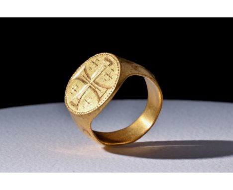 Ca. 1000-1300 AD.A heavy medieval gold ring with a elaborate design, featuring a flat D-shaped hoop and a circular bezel. Ins