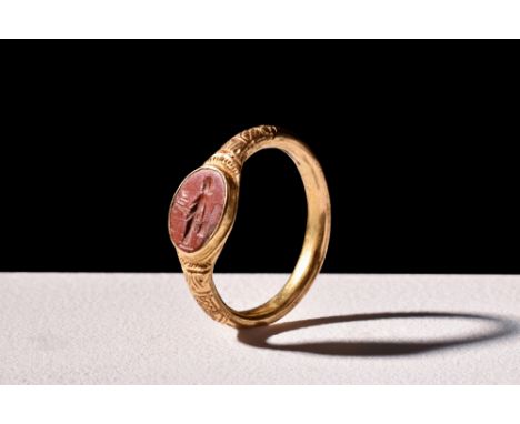 Ca. 100 AD.A gold finger ring with a rounded hoop and intricate decorations on the shoulders. It holds a jasper intaglio show