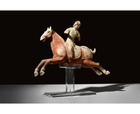 Ca. 618-907 AD.A terracotta polo rider on a hollow-moulded horse. The rider's face is detailed with red cheeks, expressive ey
