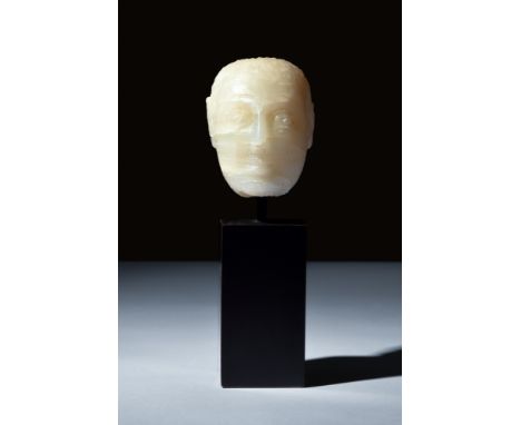 Ca. 200 BC-100 AD.An oval-shaped alabaster head with delicate features, including finely detailed ears, wide eyes, angular no