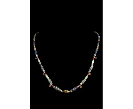 Ca. 2000-1000 BC.A necklace with restrung gold, glass, and stone beads. Symmetrical arrangement with alternating materials. G