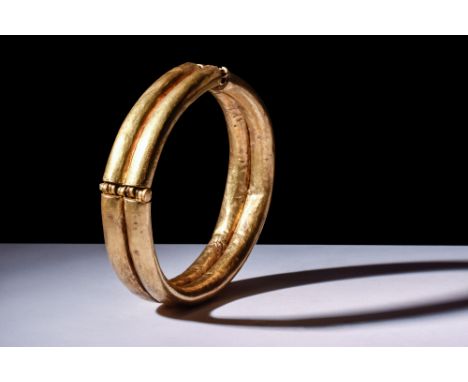 Ca. 500-400 BC.A gold bracelet, circular in shape, made from two joined tubes with a central groove. It represents the artist