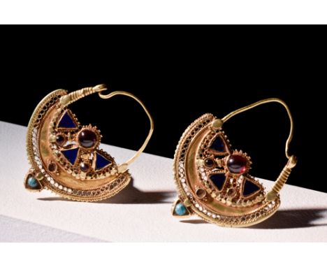 Ca. 800 AD.A pair of meticulously crafted earrings showcasing an elaborate design. Fastened with a gold wire hook and eye clo