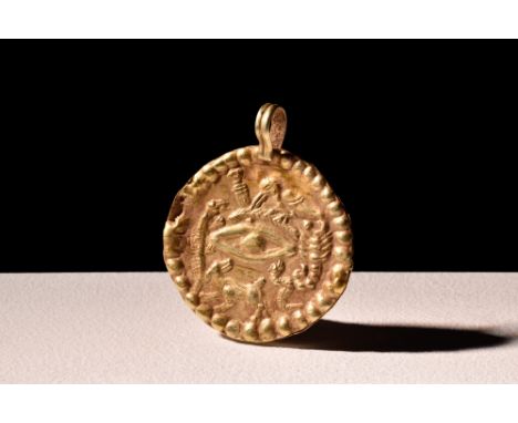 Ca. 100 AD.A gold pendant moulded in a circular shape with a raised dotted border. It features an eye symbol in the centre, s