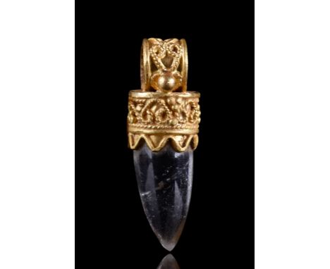 Ca. 300-100 BC.A gold pendant with intricate filigree work and a circular suspension loop. It contains a rock crystal cut int