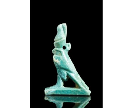 Late Dynastic Period, Ca. 664-332 BC.A faience amulet of Horus shaped like a falcon with a flat base, prominent eyes, facial 