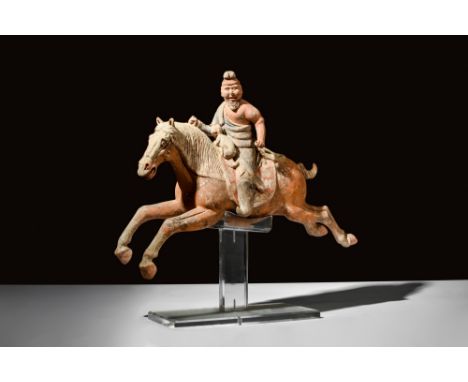 Ca. 618-907 AD.A terracotta sculpture of a Sogdian rider on a galloping horse. The rider's face features a finely crafted bea