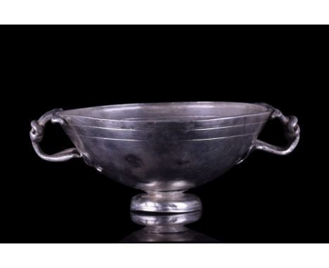 Ca. 200 AD.A silver kylix with a hemispherical bowl, resting on a concave foot, with two equally spaced loop handles shaped a