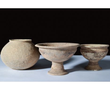 Ca. 3000-2500 BC.A set of three terracotta vessels, including two chalice cups with flared stem feet, deep basins, and everte