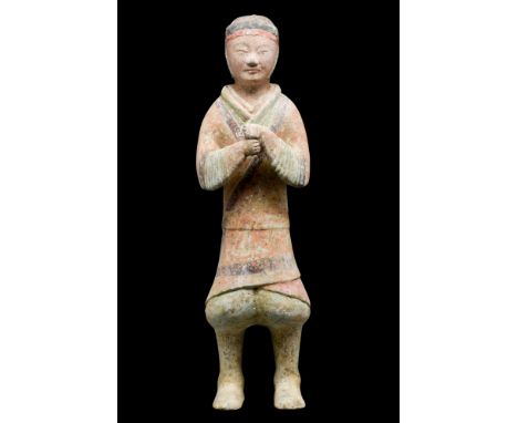 Ca. 206 BC-220 AD.A polychrome ceramic figure of a soldier. He stands resolute, clad in a cross-over coat and puffy trousers.