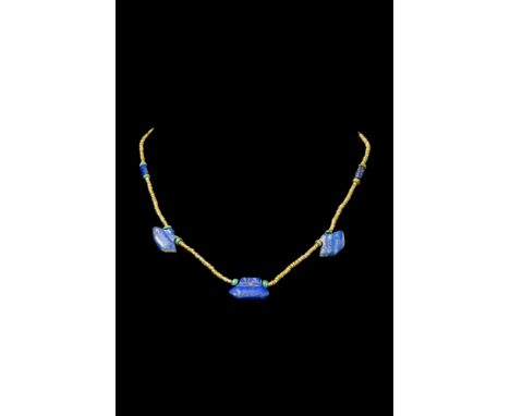 Ca. 2000-1000 BC.A beaded necklace combines gold, lapis lazuli, and green beads, creating a luxurious and elegant piece. Lapi