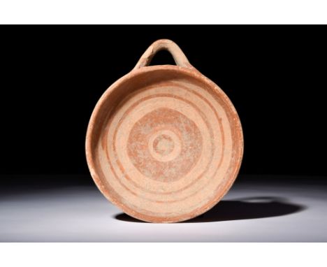 Ca. 400 BC.A ceramic kyathos with a rounded, shallow bowl and a side loop handle. Ochre concentric bands decorate the inner b